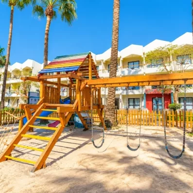 air de jeux pour enfant en bois à l'extérieur de l'hôtel, palmiers, soleil