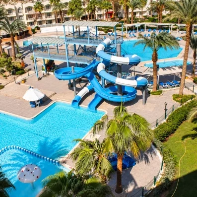 Vue de haut des toboggans aquatiques, des deux grandes piscines, et  de la petite piscine, palmiers 