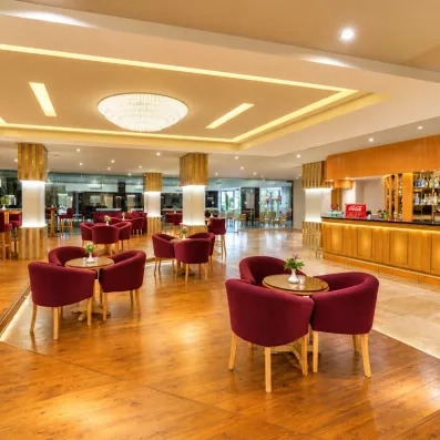 lobby bar avec tables et chaises en bordeaux, ambiance chaleureuse 