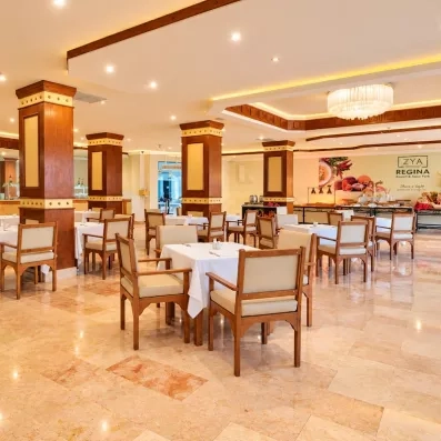 Salle du restaurant principal de l'hôtel avec chaises et tables dressées 