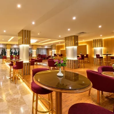 lobby bar avec tables hautes chaises en bordeaux, ambiance chaleureuse 