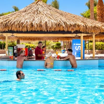 Comptoir de bar au bord de la piscine avec un bar man et des touristes 