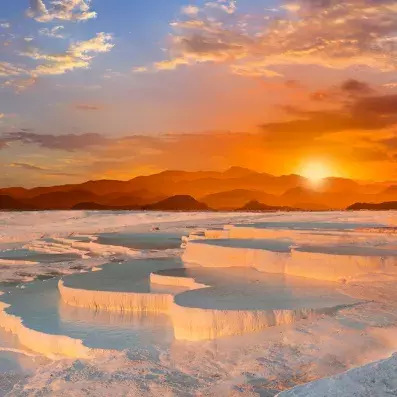 Vasques de calcaire de Pamukkale près d’Izmir au coucher du soleil, eaux laiteuses et terrasses naturelles classées UNESCO.