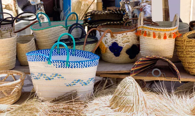 plusieurs paniers colorés en osier de fabrication artisanal dans un marché tunisien