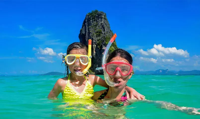 mère et fille avec masque et tuba dans les eaux turquoise de la thailande