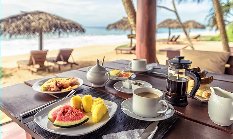 Table de petit dejeuner avec des fruits au bord de la plage