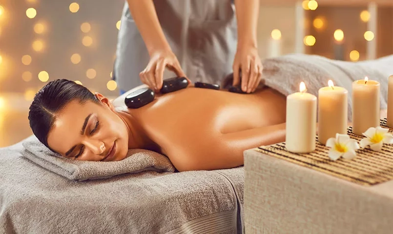 Une femme qui fait un massage relaxant aux pierres chaudes. 