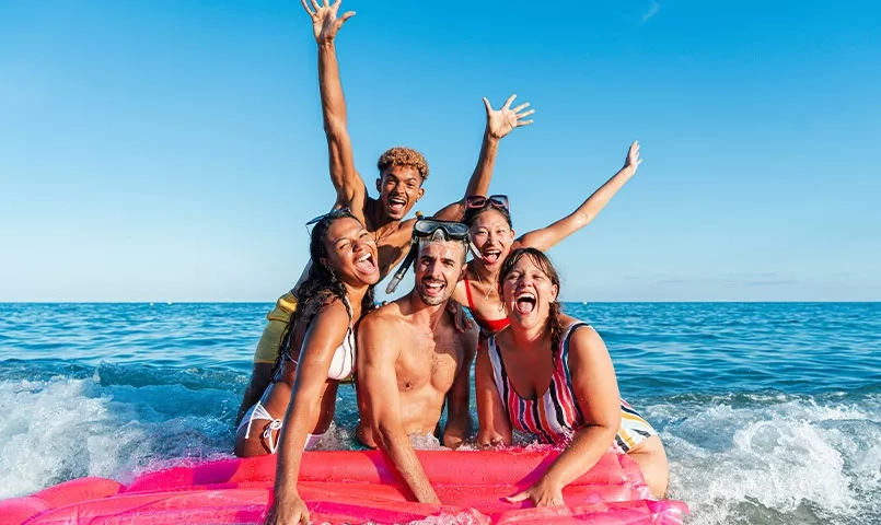 Un groupe de jeunes gens sur un matelas gonflable dans l'eau. 