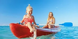 Une femme et un enfant sur un canoë sur la mer turquoise