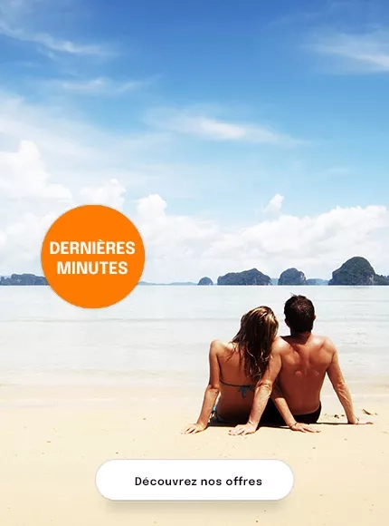 un couple assis sur une plage face à la mer
