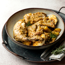 Plat traditionnel canarien de lapin en salmorejo à Tenerife, viande mijotée aux épices servie dans une assiette rustique.