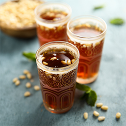 3 verres de thé à la menthe proposés avec des pignons de pin, une spécialité tunisienne