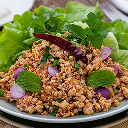 Salade de viande hachée servi avec des feuilles de salade verte